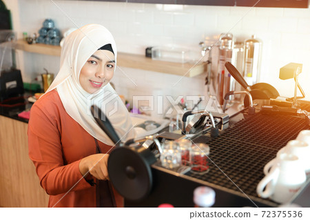 young muslim barista girl making coffee young muslim barista girl making coffee 72375536