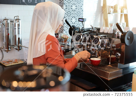 young muslim barista girl making coffee young muslim barista girl making coffee 72375555