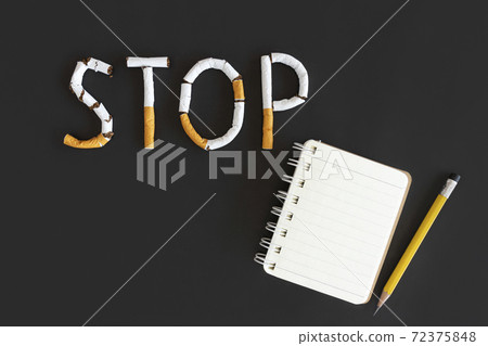 Overhead view of stop text from cigarette with copy space and note , Stop smoking initiative concept of breaking cigarettes with workplace and pencil, Top view no smoke text on black background, World Overhead view of stop text from cigarette with copy space and note , Stop smoking initiative concept of breaking cigarettes with workplace and pencil, Top view no smoke text on black background, World 72375848
