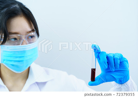 Scientist analyzing holding blood sample in test tube 72379355