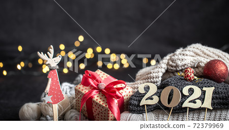 New year's composition with wooden new years number and sweaters on a dark background. 72379969