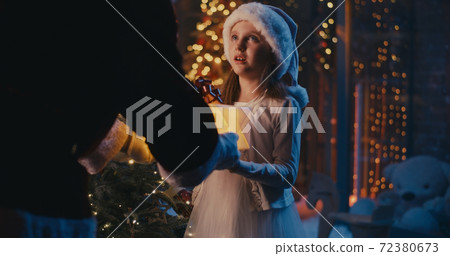 Crop Santa Claus giving present to cute girl Crop Santa Claus giving present to cute girl 72380673