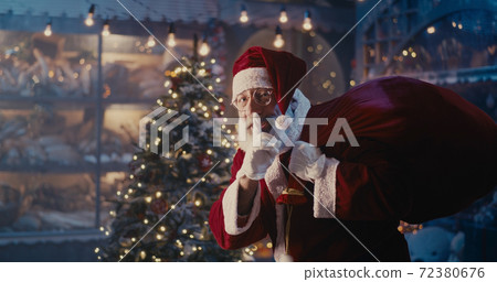 Happy Santa Claus walking quietly near Christmas tree Happy Santa Claus walking quietly near Christmas tree 72380676