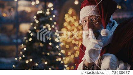 Happy Santa Claus walking quietly near Christmas tree Happy Santa Claus walking quietly near Christmas tree 72380677