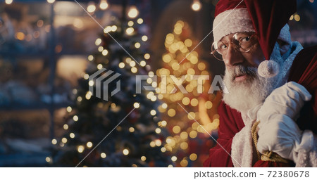 Happy Santa Claus walking quietly near Christmas tree Happy Santa Claus walking quietly near Christmas tree 72380678