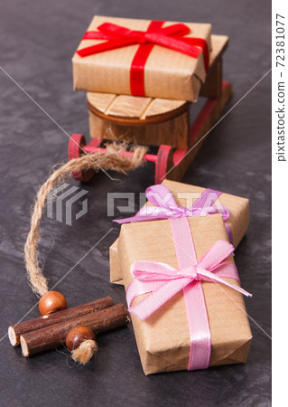 Wrapped gifts for Christmas time and wooden sled 72381077