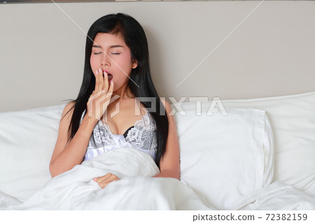 young woman yawning before go to sleep in bedroom young woman yawning before go to sleep in bedroom 72382159