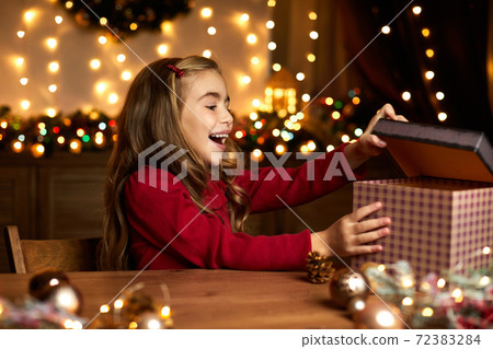 little child girl opening magic Christmas gift box little child girl opening magic Christmas gift box 72383284