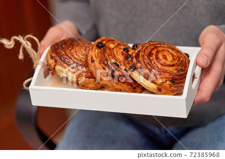 Hands holding a wooden box with buns Hands holding a wooden box with buns 72385968