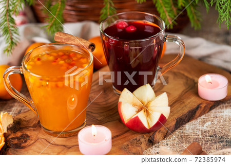 Red and yellow mulled wine in glass mugs on the christmas table Red and yellow mulled wine in glass mugs on the christmas table 72385974