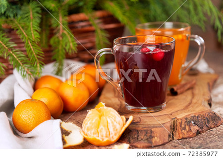 Tangerines and mulled wine in transparent mugs on the christmas table Tangerines and mulled wine in transparent mugs on the christmas table 72385977