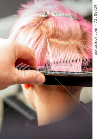 Hairdresser straightening short pink hair 72388724