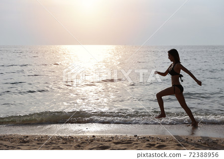 happiness on holiday silhouette side view image of young asian beautiful and sexy girl in black bikini who running on sandy beach in sunset on summer vacation happiness on holiday silhouette side view image of young asian beautiful and sexy girl in black bikini who running on sandy beach in sunset on summer vacation 72388956
