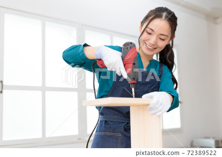 DIY girls driving screws with an electric drill 72389522