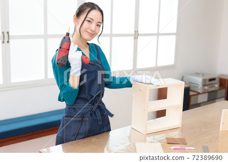 DIY girls who are pleased with the completion of the work with an electric drill in one hand 72389690
