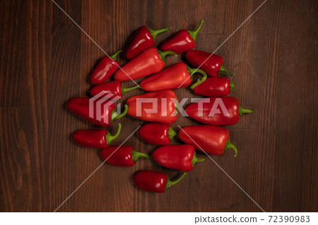 Top view. Stack of red pepper laid out on the wooden table. Large amount of red chilli peppers or capsicum 72390983