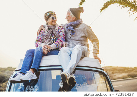 Couple of old senior traveler sit down together on the roof of the van enjoy the sunset time together with love - forever and vacation concept for traveler retired people Couple of old senior traveler sit down together on the roof of the van enjoy the sunset time together with love - forever and vacation concept for traveler retired people 72391427