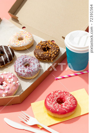 Set of yummy colorful donuts in paper box on pink background 72391564