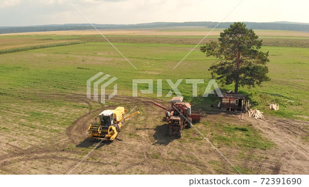Aerial view from drone of agriculture combine and harvesters on wide brown field Aerial view from drone of agriculture combine and harvesters on wide brown field 72391690