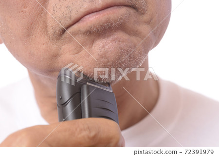 Japanese senior man shaving with an electric shaver Japanese senior man shaving with an electric shaver 72391979