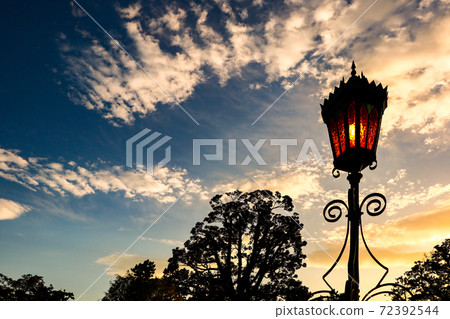 A streetlight on the border between the blue sky and the setting sun A streetlight on the border between the blue sky and the setting sun 72392544