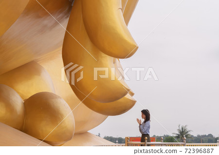 Asian woman Pay respect at the finger of Giant Golden Buddha in Wat Muang in Ang Thong district near Bangkok. Urban town city, Thailand. 72396887