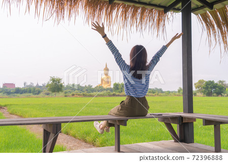 Happy Asian woman travelling at Giant Golden Buddha in Wat Muang in Ang Thong district  with paddy rice field near Bangkok. Urban town city, Thailand. Lifestyle 72396888