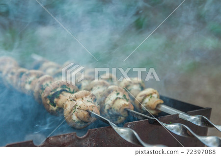 Grilled mushrooms on skewers cooked in a brazier, close-up, retro effect 72397088