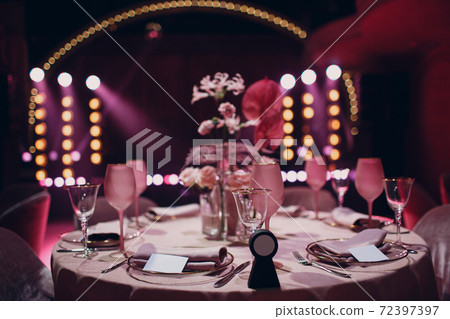 Romantic dinner pink decor table at restaurant with stage 72397397