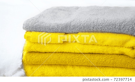 Stack of towels in Color of the Year 2021 - bright illuminating yellow and gray colours. 72397714