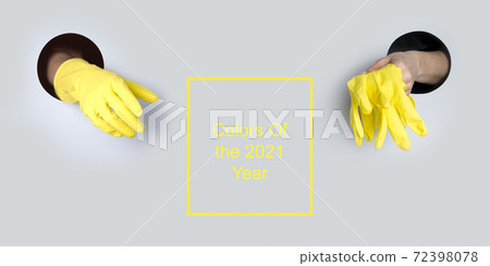 Protective yellow gloves in hand through hole. Protective yellow gloves in hand through hole. 72398078