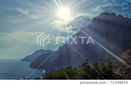 Amalfi coast beautiful picturesque view of rocky mountains Lattari in the fog and shining sun rays at Tyrrhenian sea. 72399650