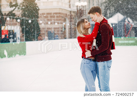 Cute and loving couplein a red sweaters in a winter city Cute and loving couplein a red sweaters in a winter city 72400257