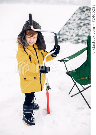 Cute little boy sitting on a winter fishing Cute little boy sitting on a winter fishing 72400285