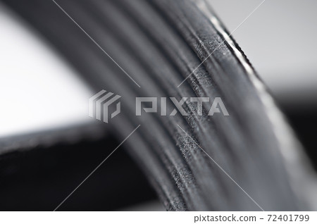 new poly V-ribbed alternator belt on gray background close-up macro view new poly V-ribbed alternator belt on gray background close-up macro view 72401799