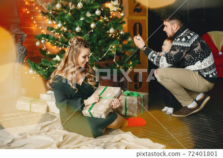 Cute family sitting near Christmas tree Cute family sitting near Christmas tree 72401801