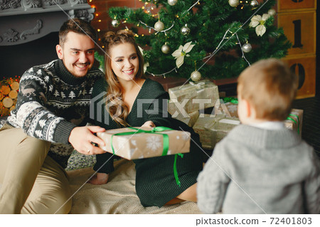 Cute family sitting near Christmas tree Cute family sitting near Christmas tree 72401803
