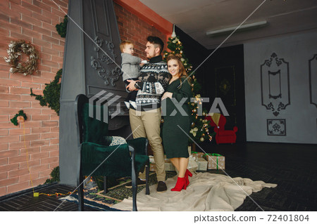 Cute family sitting near Christmas tree 72401804