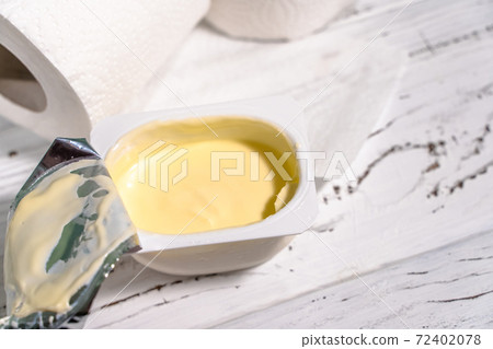 Pack of yogurt with tiolet paper on white wooden desk. 72402078