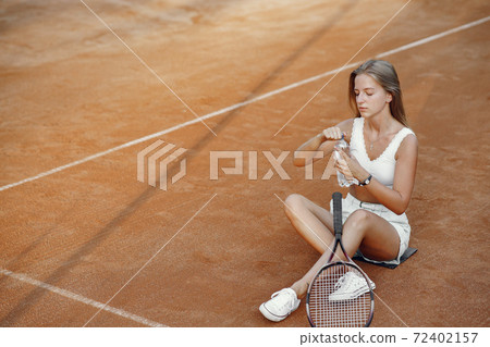 Stylish woman in a summer tennis court Stylish woman in a summer tennis court 72402157