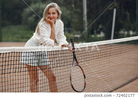 Stylish woman in a summer tennis court Stylish woman in a summer tennis court 72402177