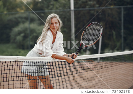 Stylish woman in a summer tennis court Stylish woman in a summer tennis court 72402178