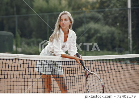 Stylish woman in a summer tennis court Stylish woman in a summer tennis court 72402179