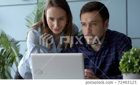 Business people working together on a computer in the office Business people working together on a computer in the office 72403125