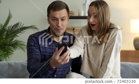 Excited happy family couple looking at digital tablet feel winners overjoyed by lottery winning bet bid, celebrate good internet news. 72403130
