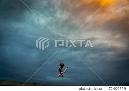 Super flexible woman jumping on the sky background. Concept of healthy lifestyle, talent and aspiration Super flexible woman jumping on the sky background. Concept of healthy lifestyle, talent and aspiration 72404539