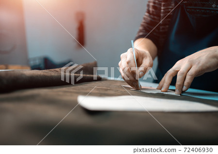 man shaping leather for shoe with knife on factory man shaping leather for shoe with knife on factory 72406930