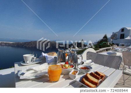 Elegant breakfast time on the balcony overlooking the Aegean Sea (Santorini) 72408944
