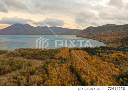 Aerial view of the autumnal trees on the shores of Lake Shikotsu Aerial view of the autumnal trees on the shores of Lake Shikotsu 72414258
