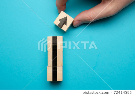 The concept of growth and business success. Wooden cubes with an arrow on a blue background. 72414595
